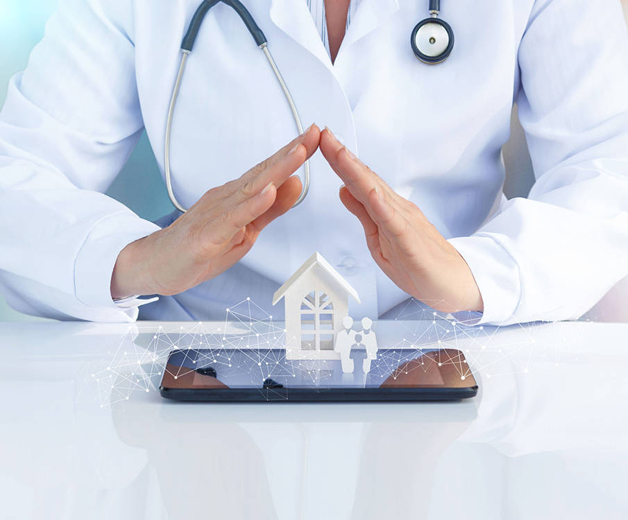 The female doctor covers with her hands the images of the house and people on the tablet in front of her